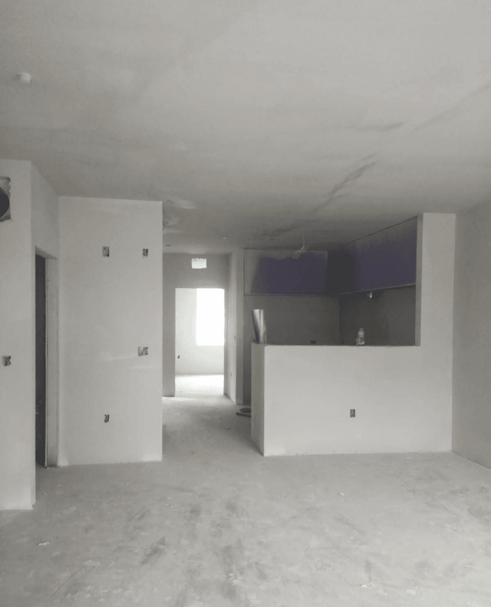 Interior room under construction featuring white drywall, purple kitchen cabinets, and unfinished concrete floors.